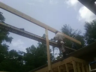 Carpenter setting a ridge beam over a new addition frame — Ice Dam Removal by Roofing Brothers in Center Line