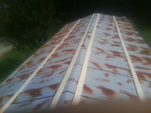 Rusted metal roof panels with new wood purlins before replacement — Storm Damage Roof Repair in Center Line by Roofing Brothers