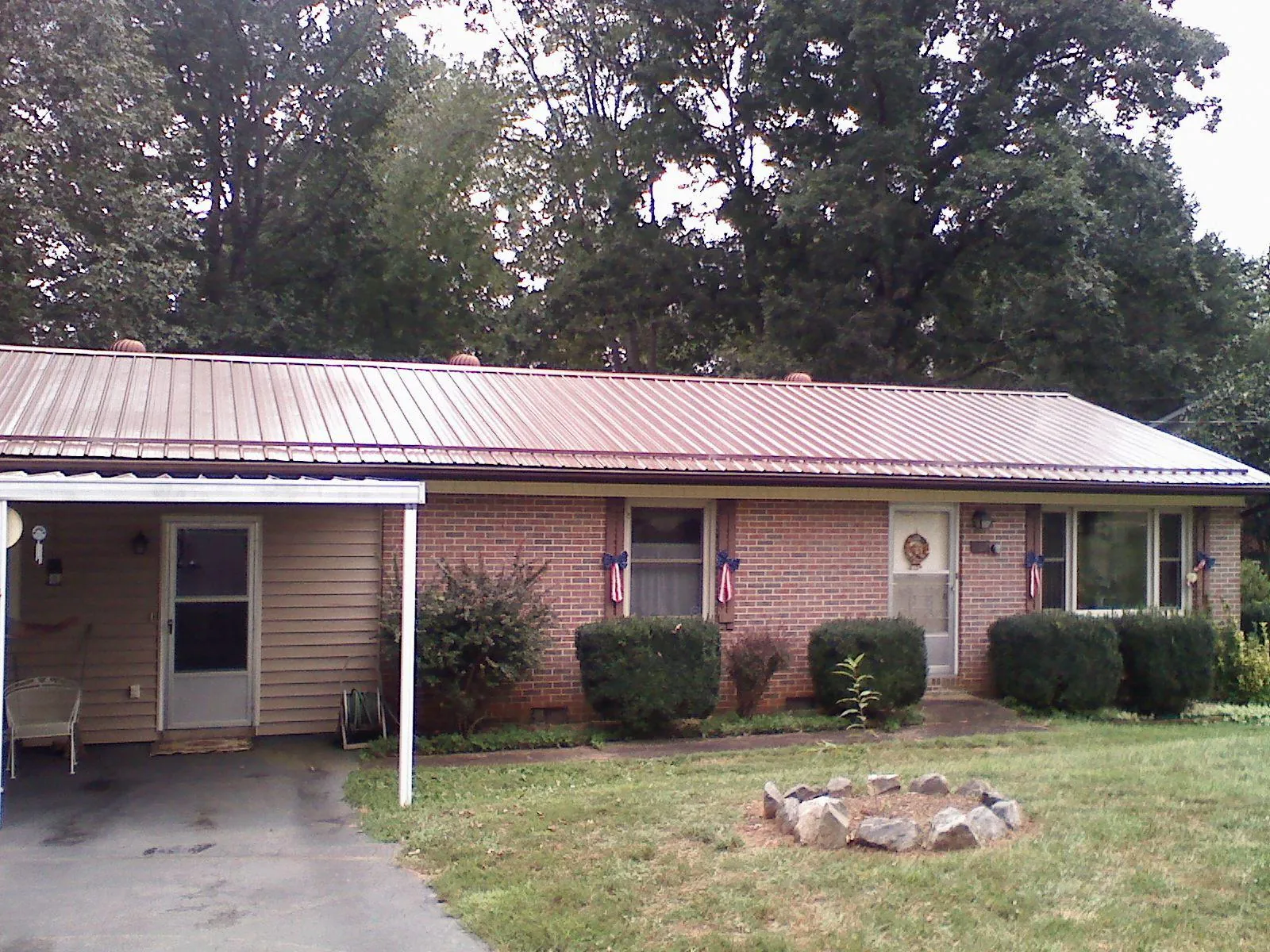 Bronze metal roof and carport on a brick ranch home — Roof Repair work by our crew in Center Line